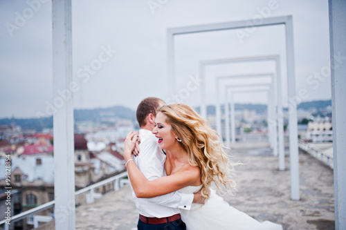 Elegant wedding couple on the roof with high-tech architecture l