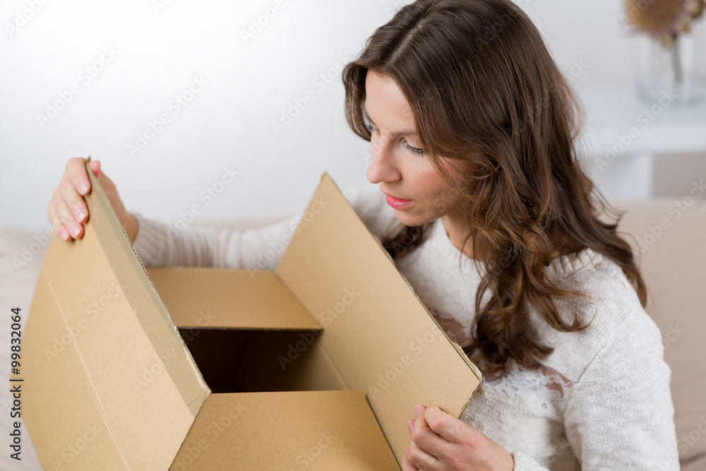 Woman unboxing her online order in the living room Woman unboxing her online order in the living room