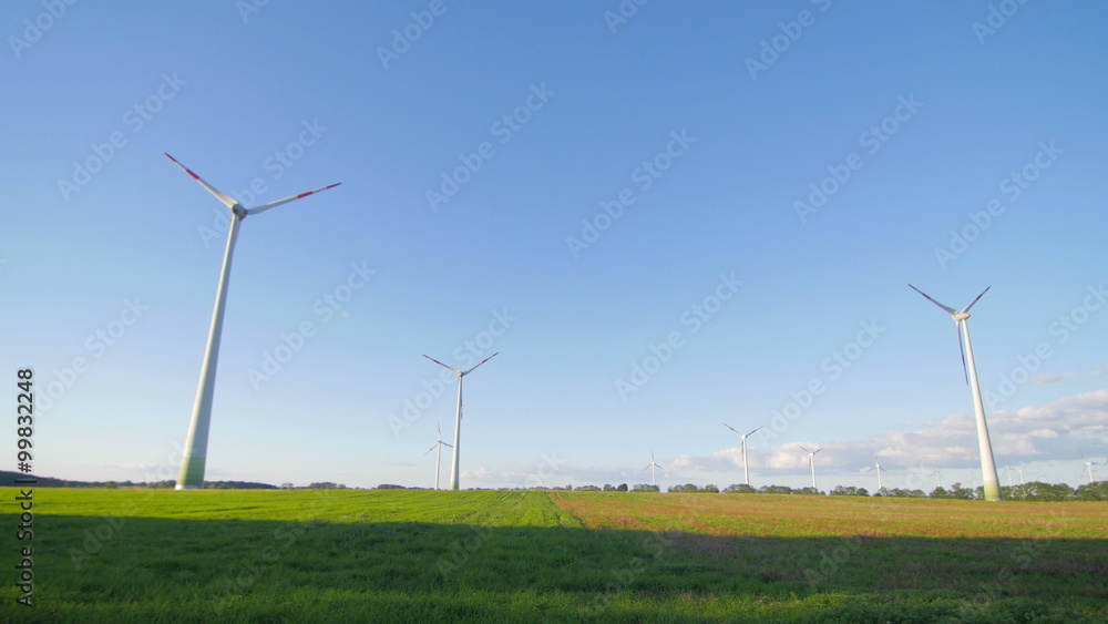 Secondary road light traffic at the sunset and wind power plants pan Secondary road light traffic at the sunset and wind power plants pan