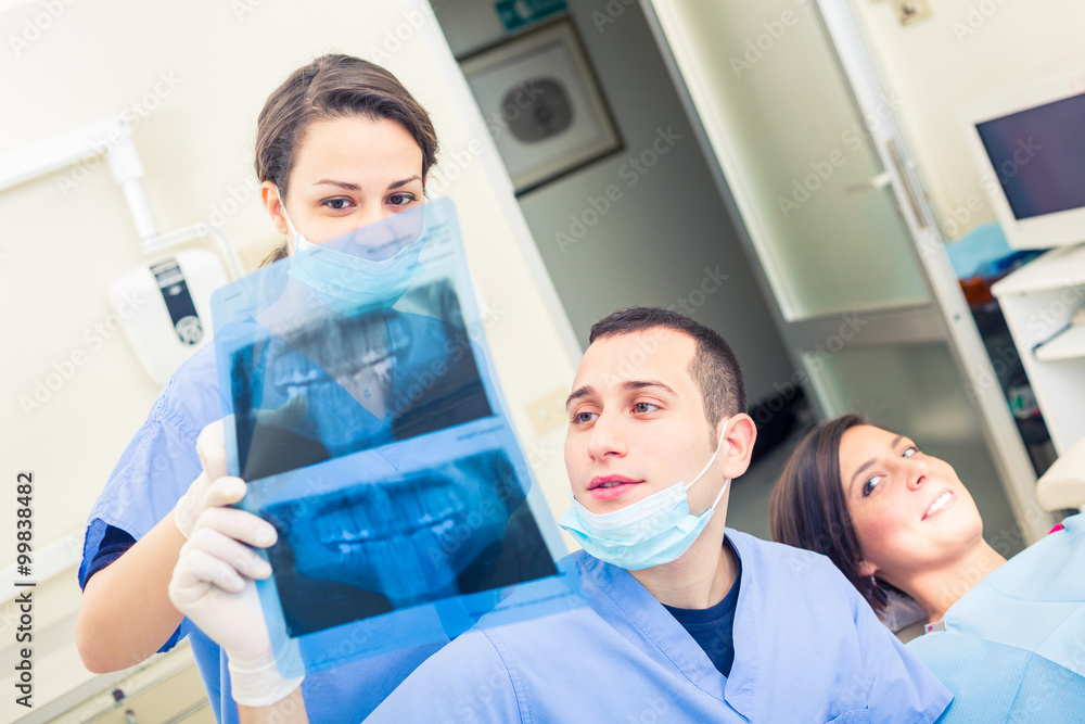 Dentist and dental assistant examining an X-ray Dentist and dental assistant examining an X-ray