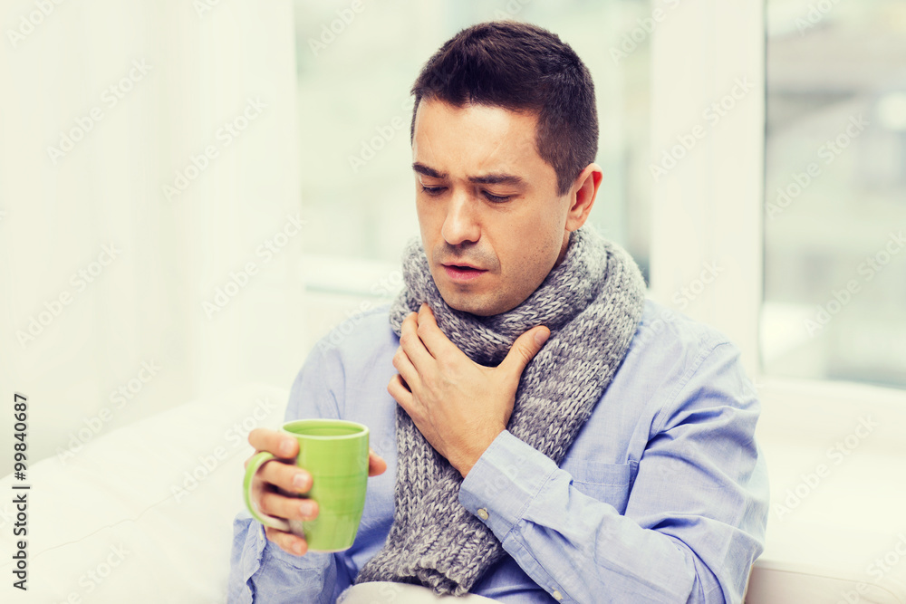 ill man with flu drinking tea and coughing at home ill man with flu drinking tea and coughing at home