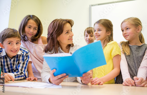 group of school kids with teacher in classroom