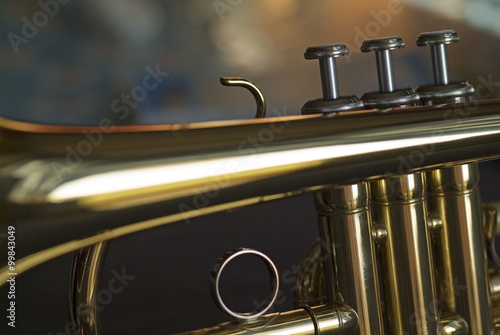 Three musical keys on a shiny trumpet.