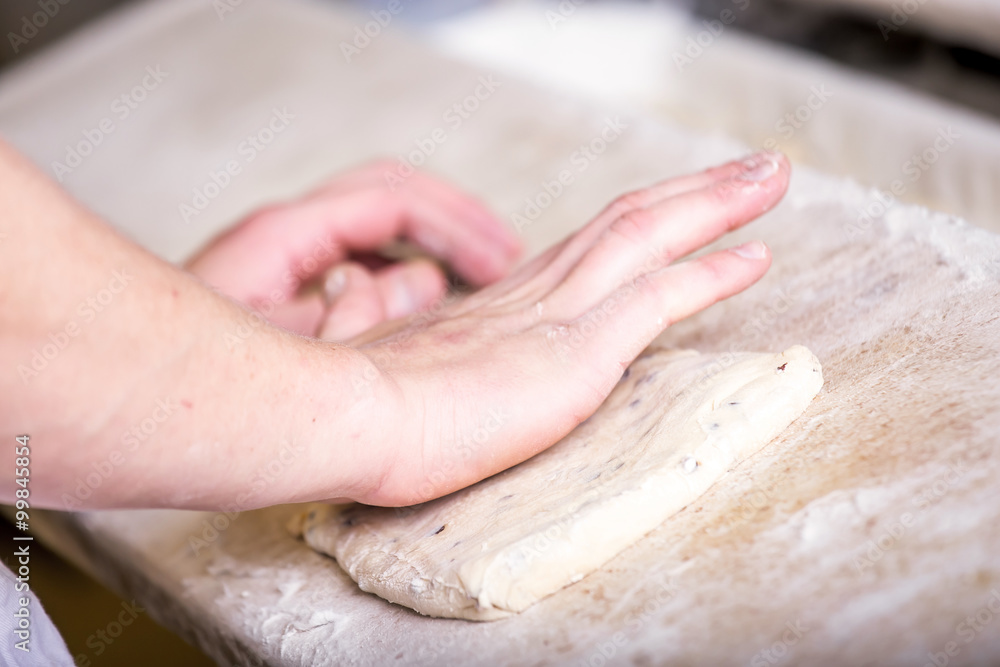 Close-up the hand of a baker kneading and shaping dough Close-up the hand of a baker kneading and shaping dough