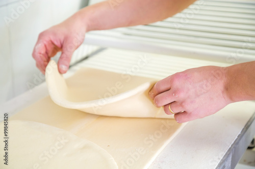 Close-up the hand of a baker kneading and shaping dough