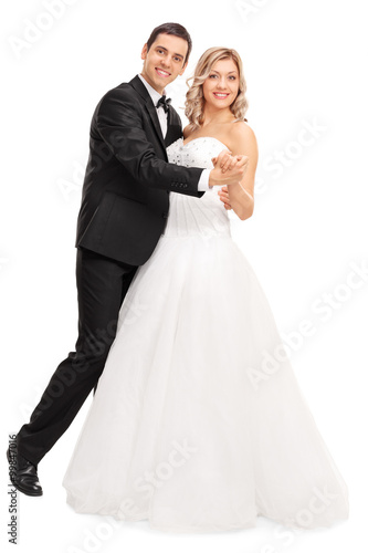 Young bride and groom dancing together