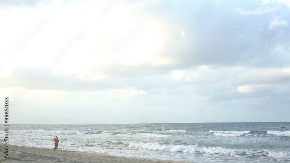 a romantic seascape with waves in a winter calm day, in Sardinia, italian island famous for its beautiful sea. with people in background a romantic seascape with waves in a winter calm day, in Sardinia, italian island famous for its beautiful sea. with people in background