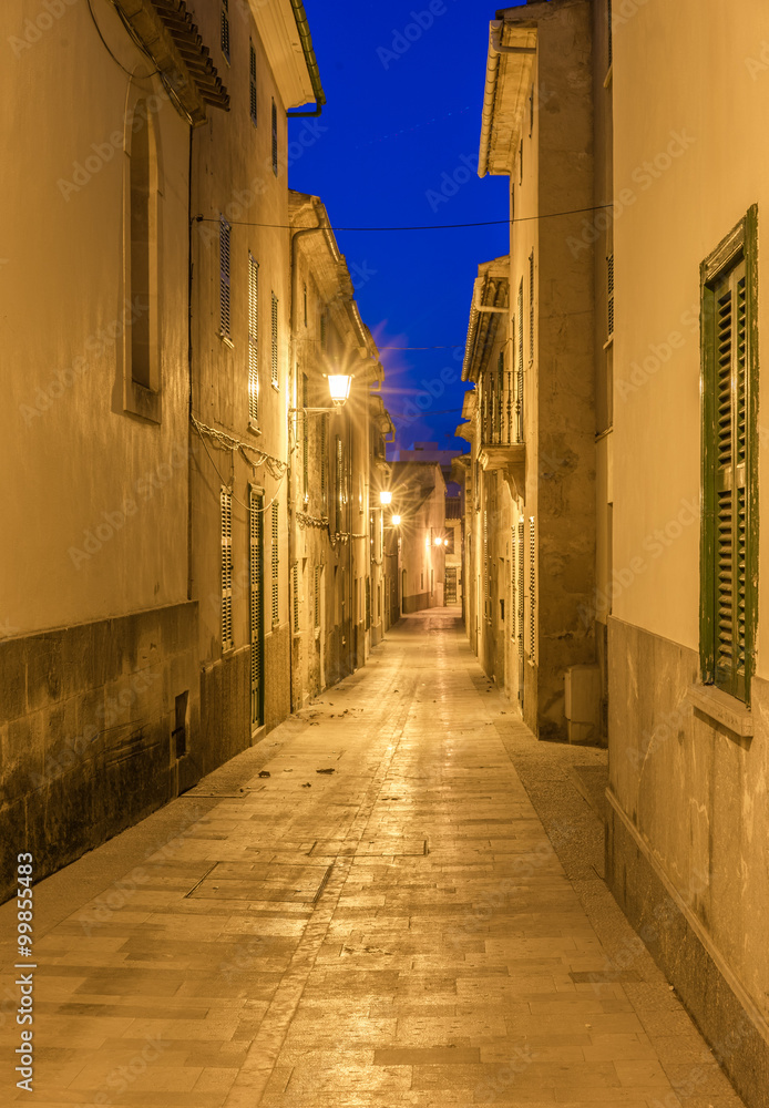 Narrow old street with lanterns at night