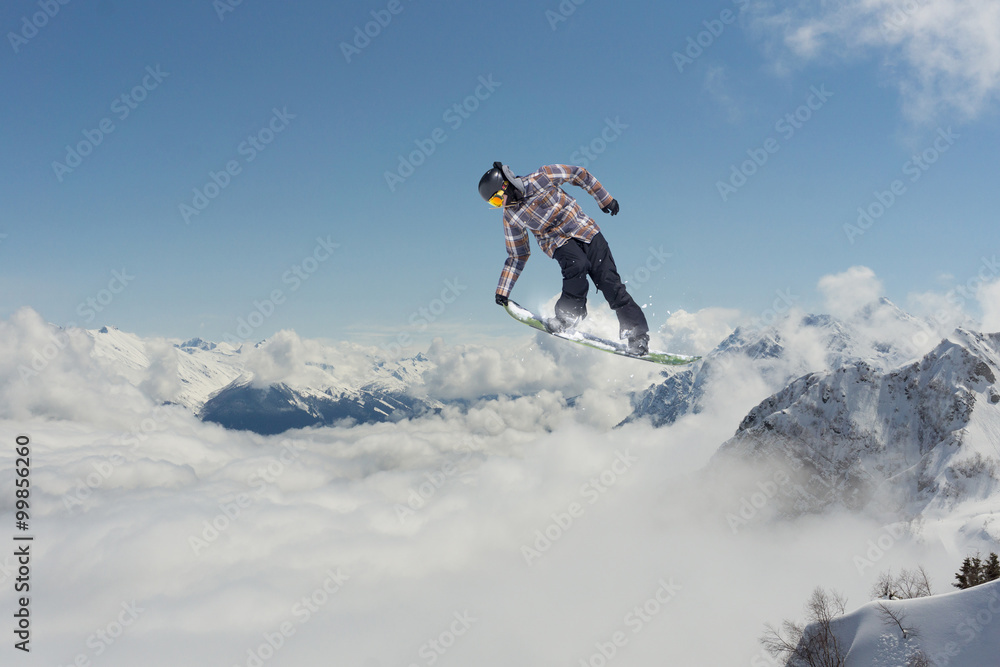 Flying snowboarder on mountains. Extreme sport.