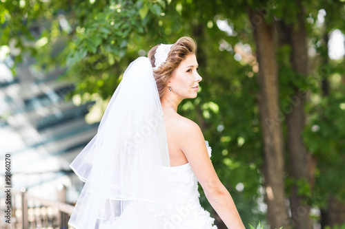 Beautiful bride outdoors with wedding bouquet
