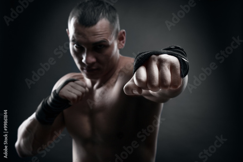 Fighter boxer and warrior's fist on black background © Restyler