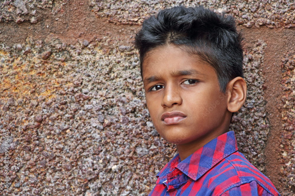 Teenage boy in angry and upset mood, red brick wall background Teenage boy in angry and upset mood, red brick wall background