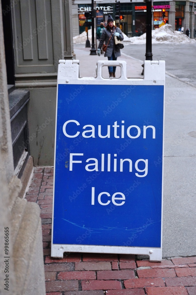 Obraz premium Caution falling ice sign on an icy sidewalk in Boston in winter