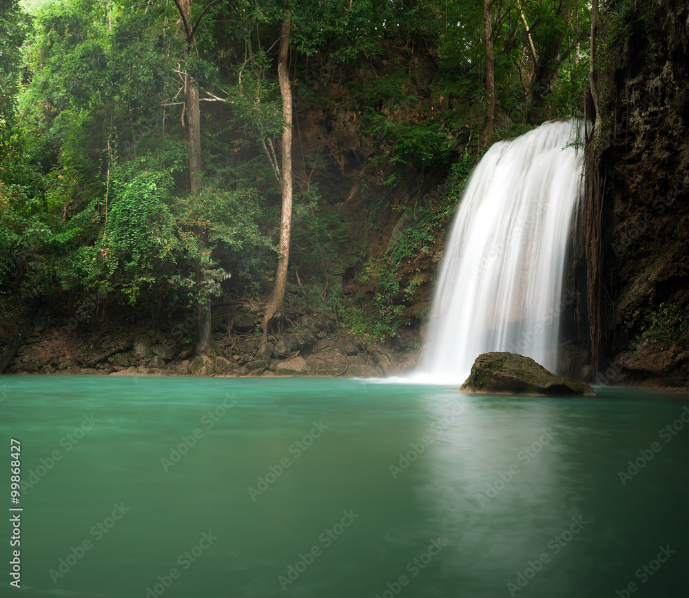 Sunlight in jungle rainforest with scenic waterfall flowing in natural pond Sunlight in jungle rainforest with scenic waterfall flowing in natural pond