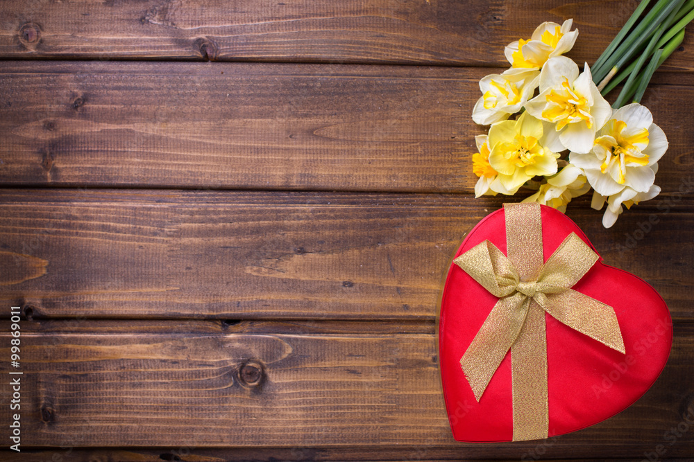 Red gift box with bow  and fresh  white and yellow narcissus flo