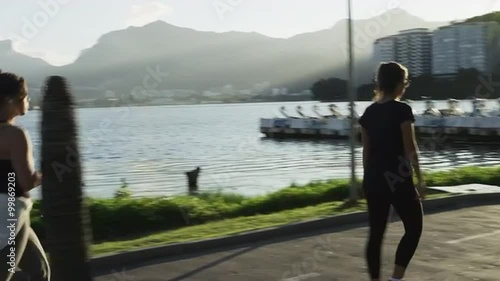 Slow-motion tracking shot of people walking on a path beside Lagoa.