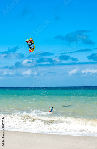 Active lifestyle sport background. Kite surfer near ocean coast beach