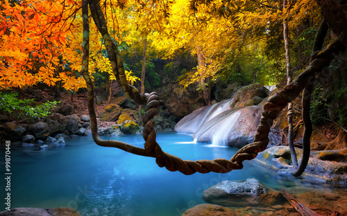 Amazing beauty of Asian nature. Tropical waterfall flows through dense jungle forest and falls into wild pond photo