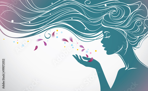 Beautiful girl with long hair blows away flower petals from her palm