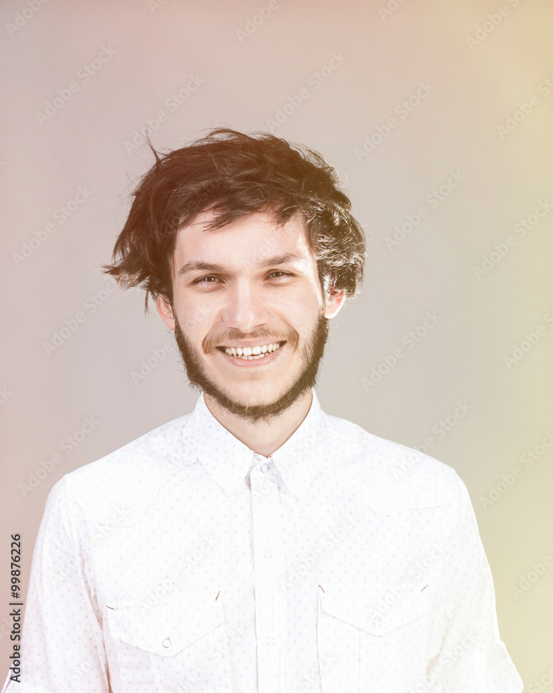 Cheerful young man with a messy hairdo. Light background. Cheerful young man with a messy hairdo. Light background.