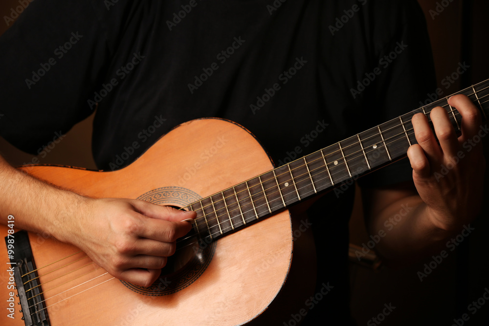 Fototapeta premium Young musician playing acoustic guitar close up