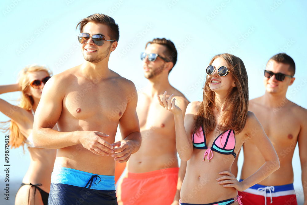 Happy young friends relaxing at the beach, outdoors