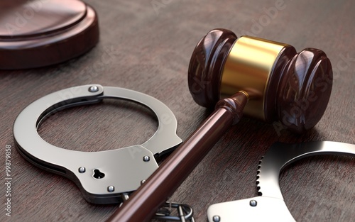  Gavel and handcuffs on wooden table background