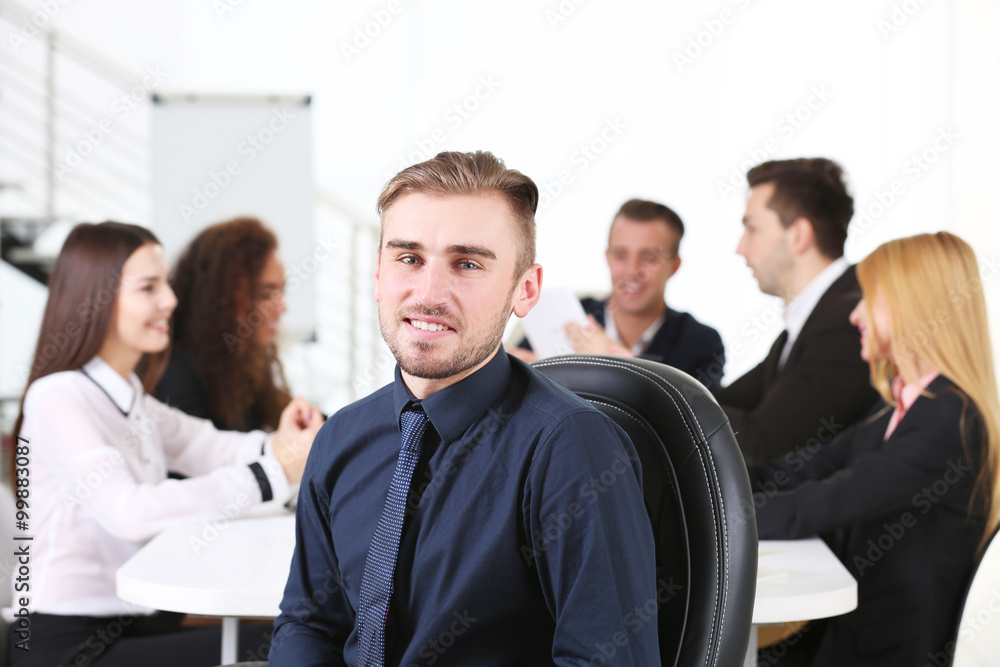 Photo of a young business man with his staff at the meeting in a conference room Photo of a young business man with his staff at the meeting in a conference room