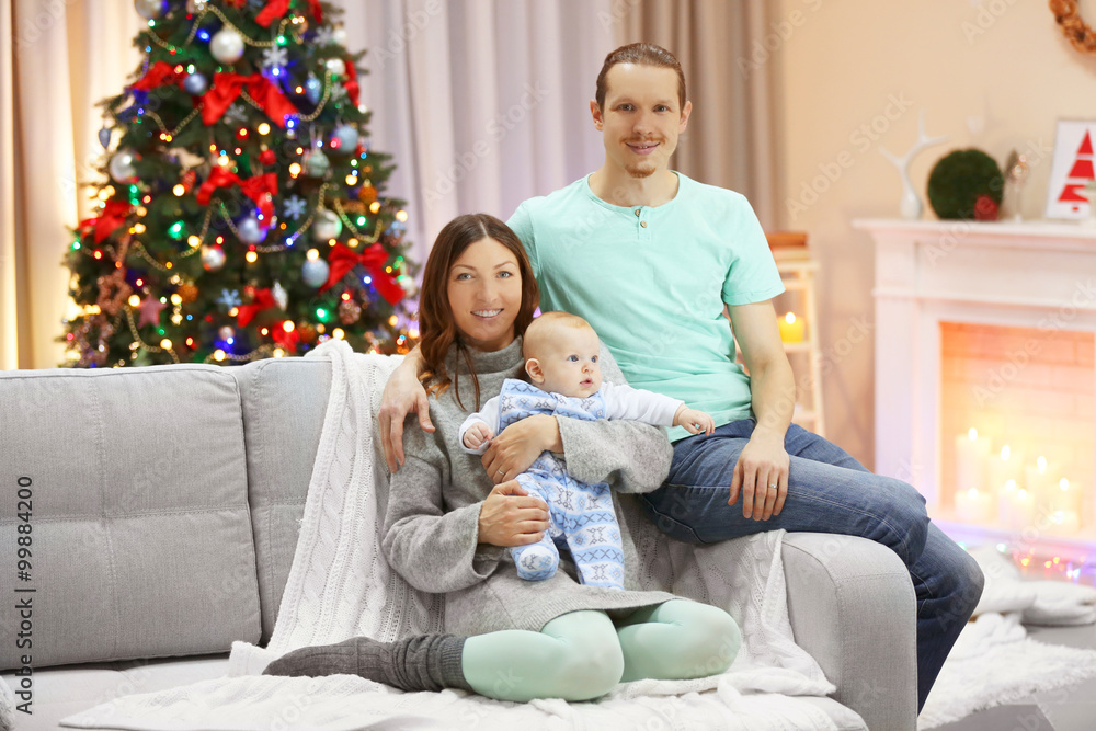 Happy family on sofa in the decorated Christmas room Happy family on sofa in the decorated Christmas room
