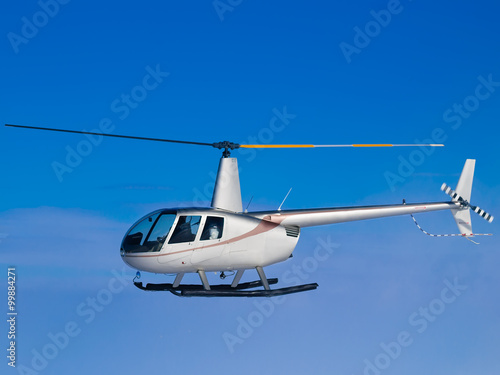 Helicopter flying in blue sky side view