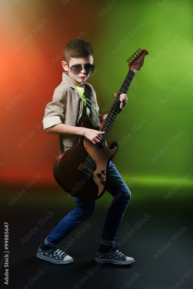 Little boy playing guitar on a bright background Little boy playing guitar on a bright background