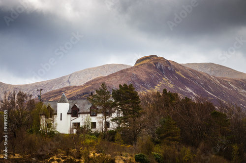 The Scottish Highlands. The Glamaig on a cloudy spring day with a white scottish cottage - Isle of Skye, Scotland, UK