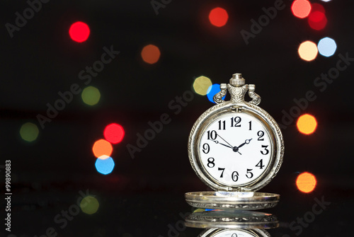 Antique pocket watch, with Christmas lights in the background