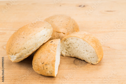 Freshly baked healthy gluten-free delicious wholemeal buns with herbs on wooden surface