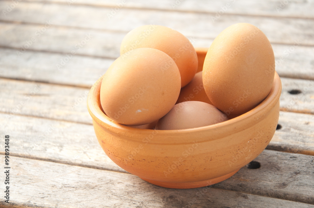 eggs in a wooden bowl on the table from the old boards eggs in a wooden bowl on the table from the old boards