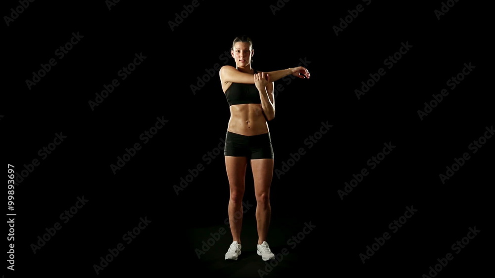 Woman wearing sporstwear is warming up isolated on black Woman wearing sporstwear is warming up isolated on black
