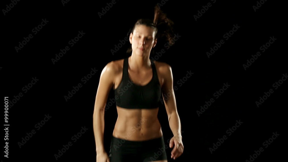 Young athletic woman wearing sporstwear is relaxing isolated on black Young athletic woman wearing sporstwear is relaxing isolated on black