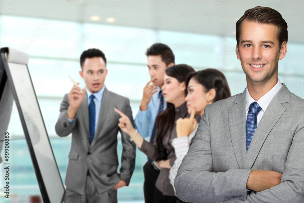 Young caucasian businessman, with his team discussing at the bac Young caucasian businessman, with his team discussing at the bac