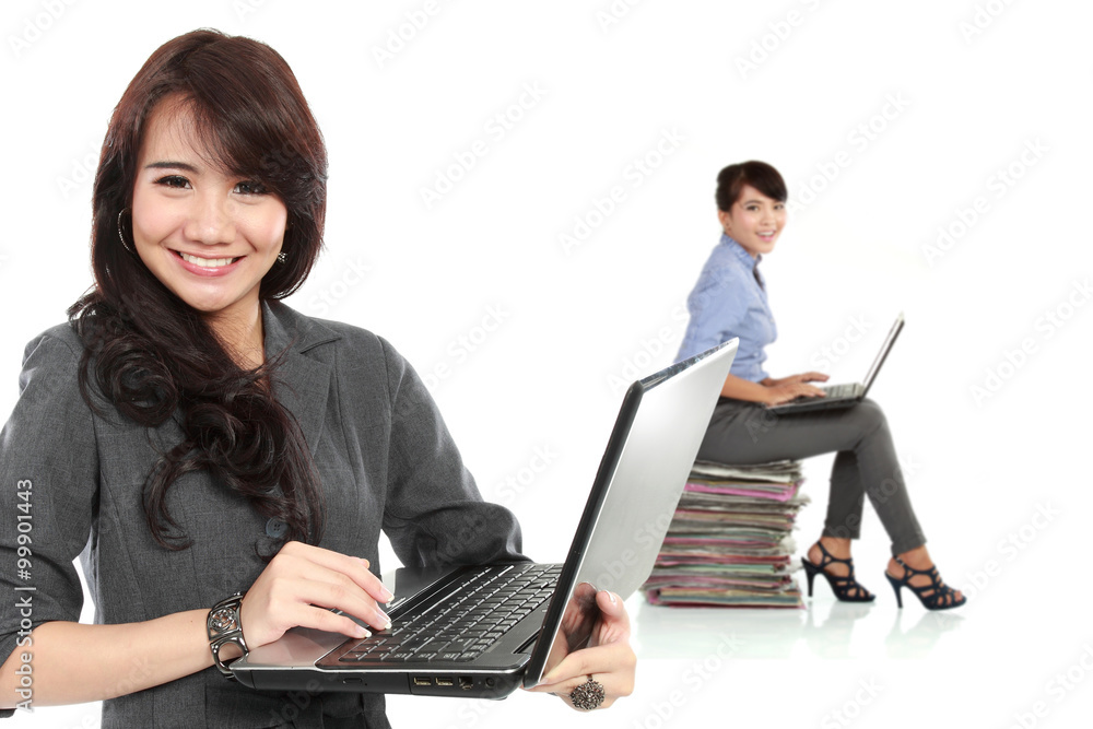 Young asian businesswoman, with her team behind holding laptop. Young asian businesswoman, with her team behind holding laptop.