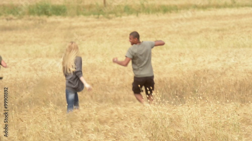 Friends having fun in summer day running in a cornfiled    photo