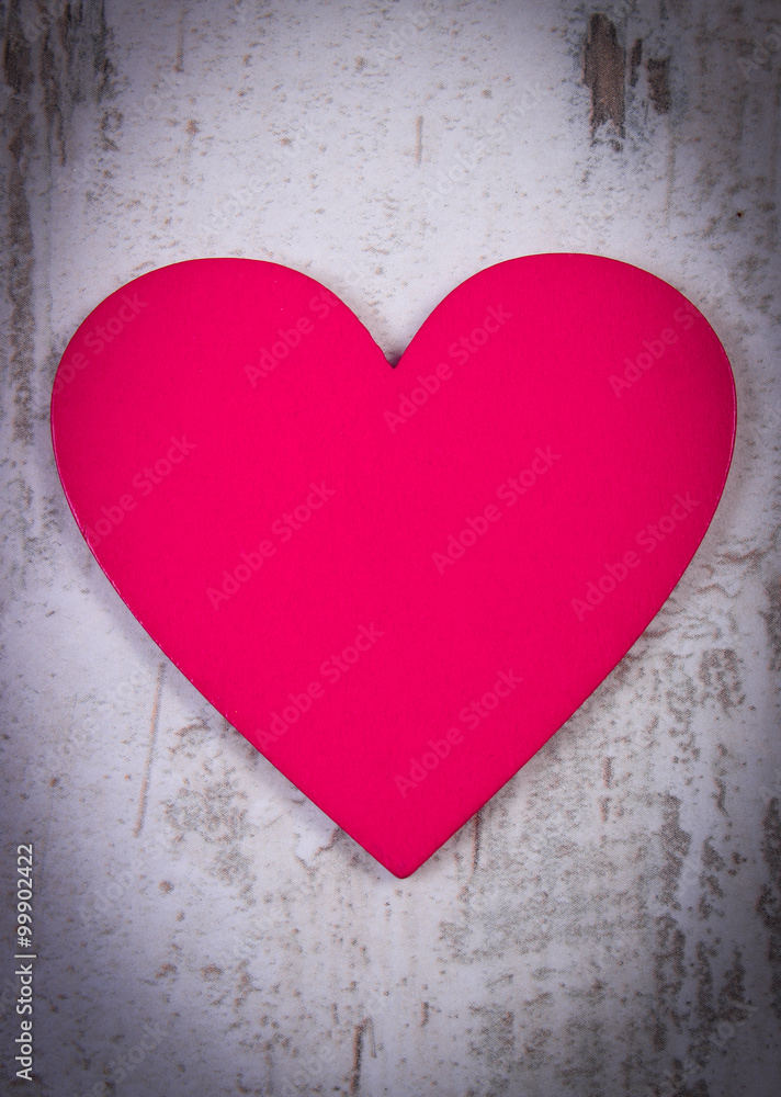Valentine pink heart on old wooden white table, symbol of love