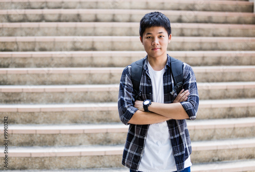 Unhappy teenage student sitting outside on stadium steps