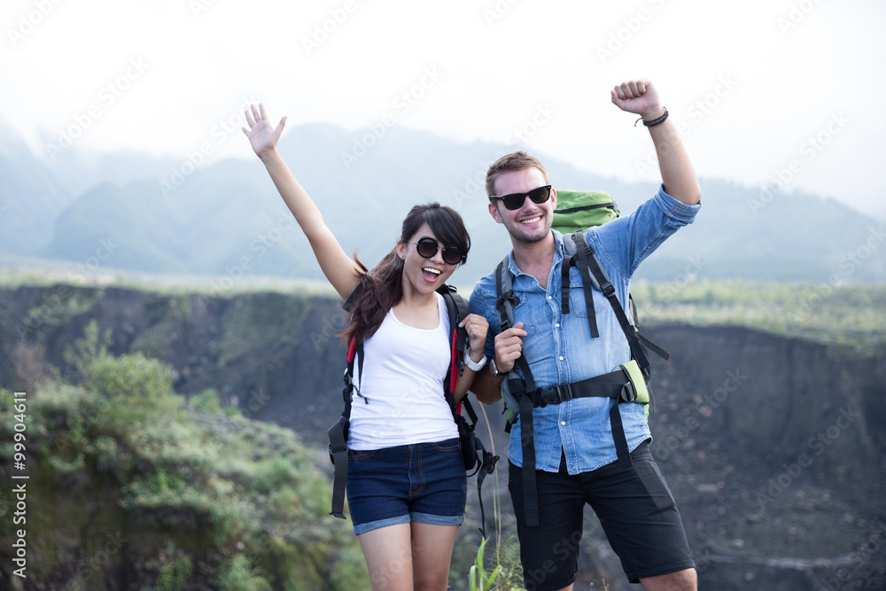 young woman and man go trekking together, nature background