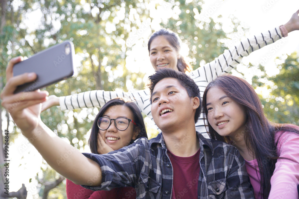 Obraz premium Group of Friends taking Self Portraits with Mobile Phone