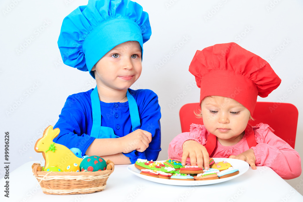 cute little boy and girl playing with easter cookies cute little boy and girl playing with easter cookies