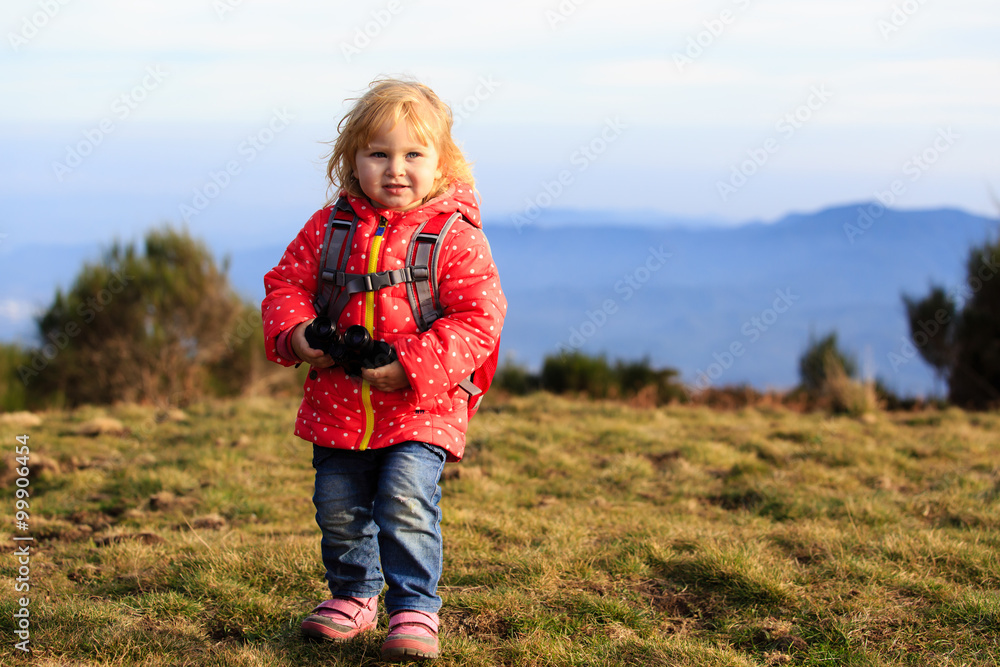 little tourist with binoculars travel hiking in mountains