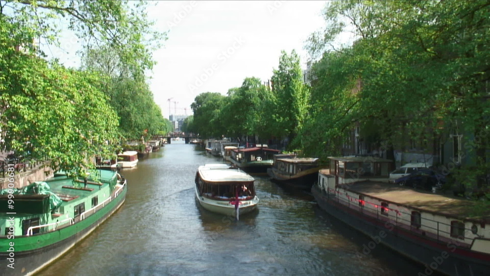 Boat traveling down a river in Amsterdam. Boat traveling down a river in Amsterdam.