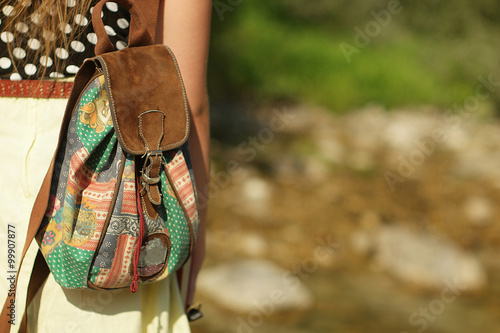Hiker young woman with backpack walking in the mountains in summer