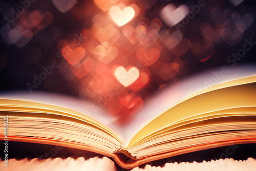 Open book against heart shaped bokeh, Valentines day concept
