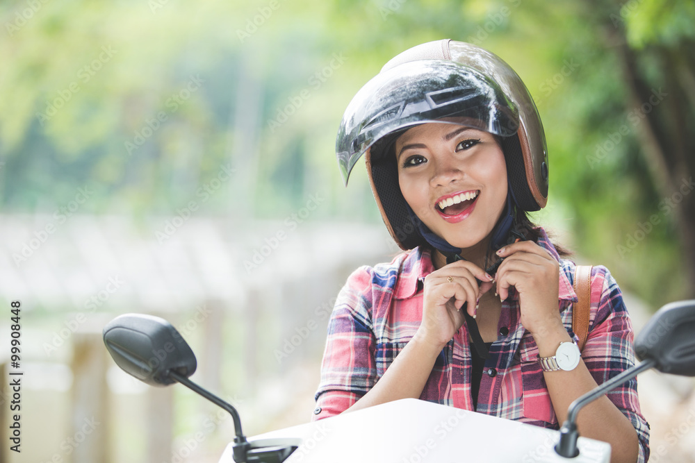 Young asian woman wearing a helmet before riding a motorcycle on Young asian woman wearing a helmet before riding a motorcycle on
